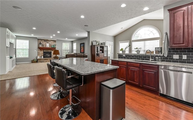 122 Brighton Ln, Adams Twp, PA 16046 - kitchen with stainless steel dishwasher, a sink, a textured ceiling, a kitchen island, and light stone counters