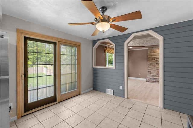 887 E Arcadia Dr, Mccandless, PA 15237 - empty room with light tile patterned floors, a ceiling fan, arched walkways, and wooden walls