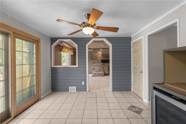 887 E Arcadia Dr, Mccandless, PA 15237 - spare room with wine cooler, light tile patterned floors, a ceiling fan, wood walls, and arched walkways