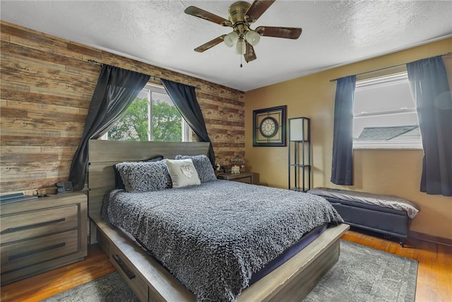 1520 Worcester Dr, Pittsburgh, PA 15243 - bedroom featuring wood finished floors, wooden walls, a textured ceiling, and a ceiling fan