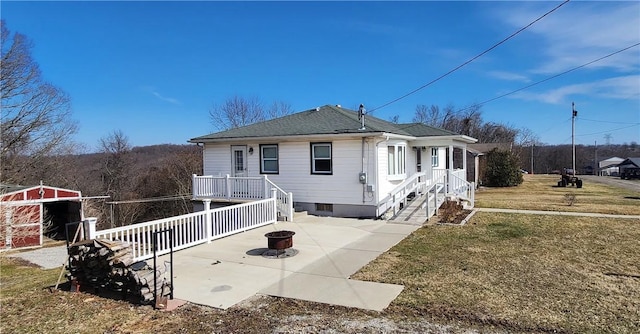32 John Dr, Hanover Twp Wsh, PA 15021 - back of property featuring a yard, a patio, roof with shingles, a fire pit, and an outdoor structure