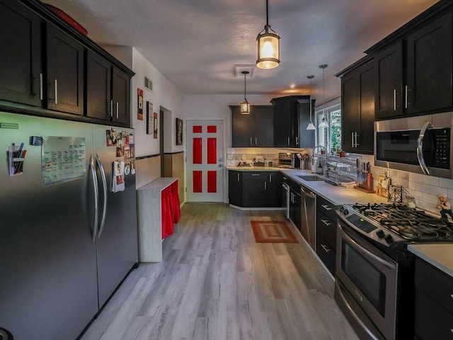 204 Biddle Ave, Regent Square, PA 15221 - kitchen with appliances with stainless steel finishes, a sink, tasteful backsplash, light countertops, and dark cabinetry
