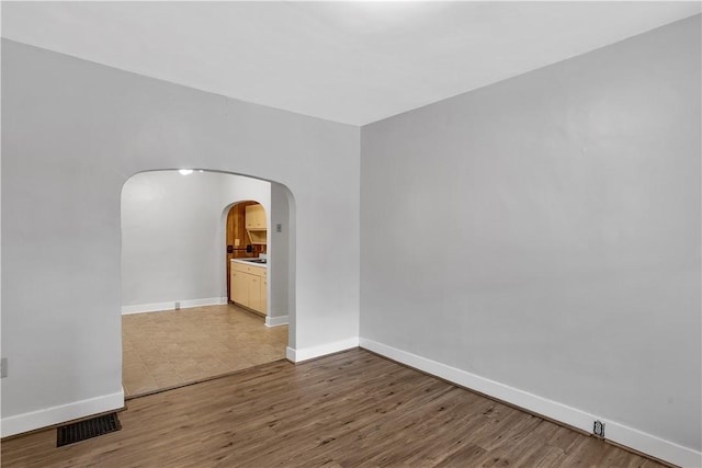 2914 5th Ave, Beaver Falls, PA 15010 - empty room with arched walkways, light wood-type flooring, and baseboards