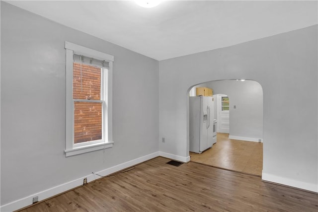 2914 5th Ave, Beaver Falls, PA 15010 - empty room with arched walkways, baseboards, plenty of natural light, and light wood-style floors
