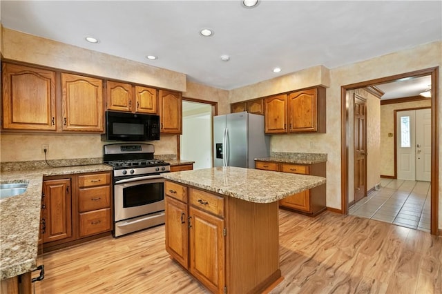 2662 Timberglen Dr W, Franklin Park, PA 15090 - kitchen with stainless steel appliances, brown cabinetry, a kitchen island, light wood finished floors, and light stone countertops