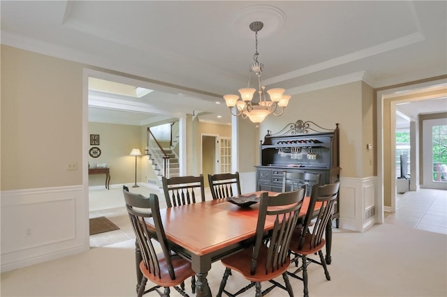 606 Adare Ct, Cranberry Twp, PA 16066 - dining space featuring a tray ceiling, crown molding, a decorative wall, wainscoting, and a chandelier