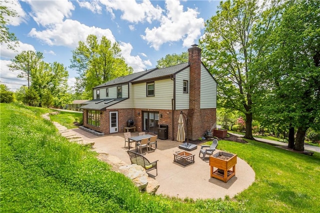 2507 Corteland Dr, Upper St Clair, PA 15241 - back of house with a fire pit, a patio, brick siding, a yard, and a chimney