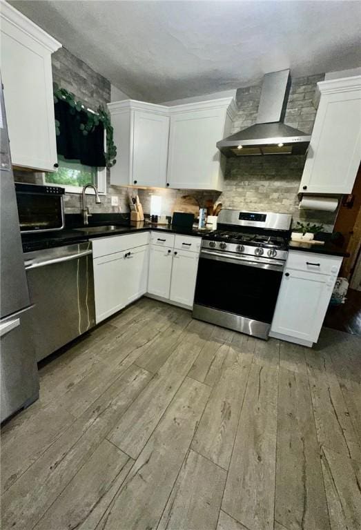 608 Wible Run Rd, Shaler, PA 15209 - kitchen with stainless steel appliances, wall chimney exhaust hood, a sink, light wood finished floors, and backsplash
