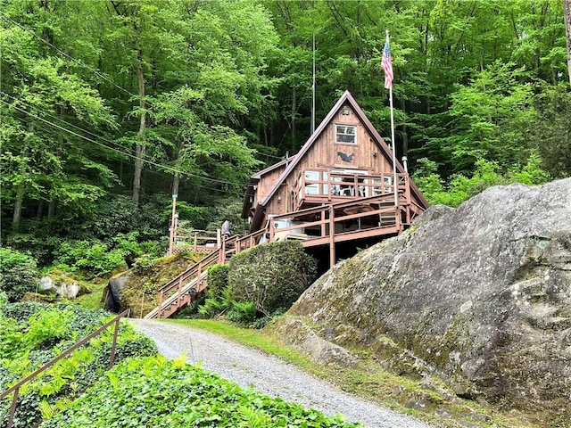 688 N Tunnel Rd, Pa, PA 16374 - back of property with a view of trees, stairs, and a wooden deck