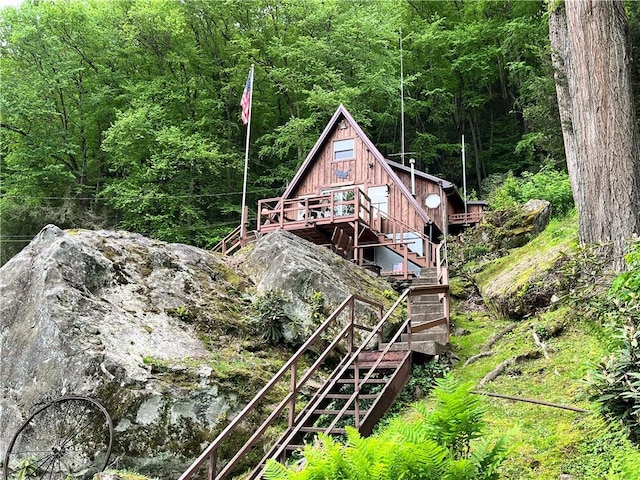 688 N Tunnel Rd, Pa, PA 16374 - back of property with stairs, a view of trees, and a wooden deck