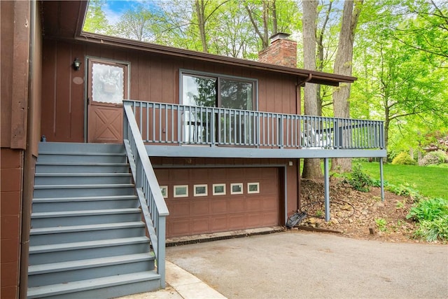 906 Aztec Trl, Coolspring Twp, PA 16137 - back of property featuring driveway, a garage, a chimney, stairway, and a wooden deck