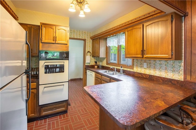 906 Aztec Trl, Coolspring Twp, PA 16137 - kitchen featuring wallpapered walls, white appliances, a sink, dark countertops, and brick patterned flooring
