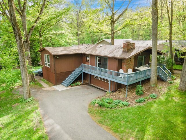 906 Aztec Trl, Coolspring Twp, PA 16137 - view of front of house with a chimney, asphalt driveway, stairs, a garage, and brick siding
