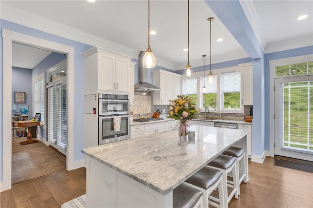 5525 Fontana Ct, Murrysville, PA 15632 - kitchen featuring wall chimney range hood, appliances with stainless steel finishes, dark wood-type flooring, white cabinetry, and light stone countertops
