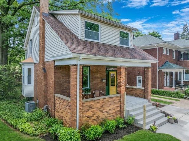 212 Orchard Pl, Sewickley, PA 15143 - view of front of home with brick siding, a chimney, roof with shingles, covered porch, and central AC unit