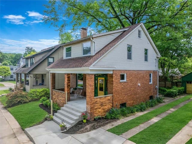 212 Orchard Pl, Sewickley, PA 15143 - view of front facade featuring a chimney, covered porch, brick siding, roof with shingles, and a front lawn