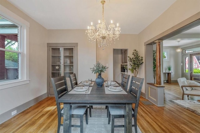 212 Orchard Pl, Sewickley, PA 15143 - dining space featuring ornate columns, light wood-style floors, a chandelier, and baseboards