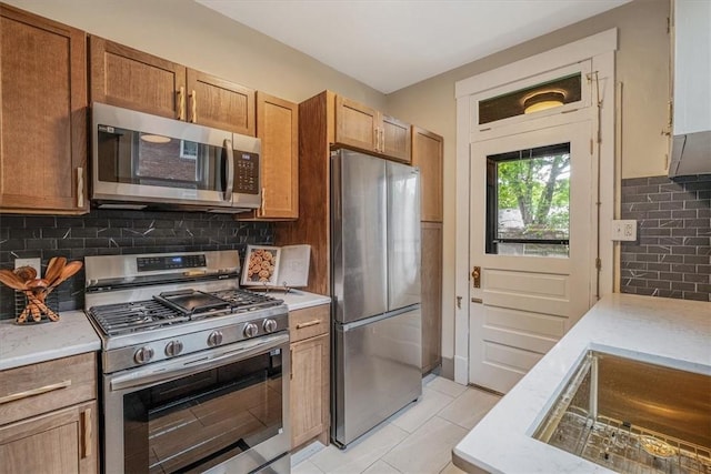 212 Orchard Pl, Sewickley, PA 15143 - kitchen featuring appliances with stainless steel finishes, tasteful backsplash, light stone countertops, and light tile patterned floors