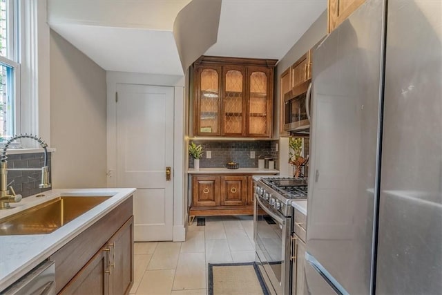 212 Orchard Pl, Sewickley, PA 15143 - kitchen with appliances with stainless steel finishes, a sink, backsplash, brown cabinetry, and light countertops