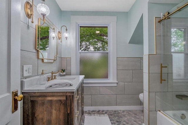 212 Orchard Pl, Sewickley, PA 15143 - bathroom with vanity, tile walls, healthy amount of natural light, toilet, and bath / shower combo with glass door