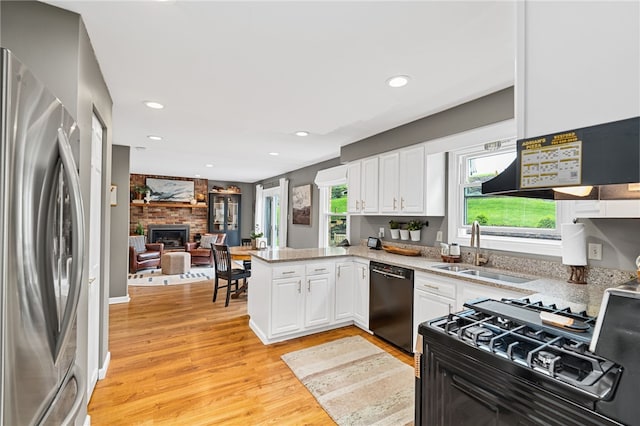 161 Ridgeview Dr, Mccandless, PA 15090 - kitchen with black appliances, a sink, white cabinets, light wood finished floors, and a peninsula