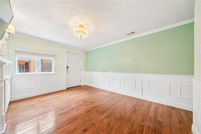 324 Orwell Way, Bloomfield, PA 15224 - empty room with wood-type flooring, ornamental molding, a wainscoted wall, a chandelier, and a decorative wall
