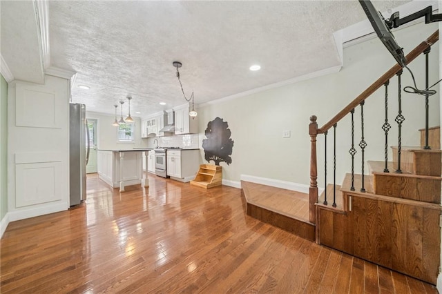 324 Orwell Way, Bloomfield, PA 15224 - living area featuring light wood-style floors, a textured ceiling, crown molding, recessed lighting, and baseboards