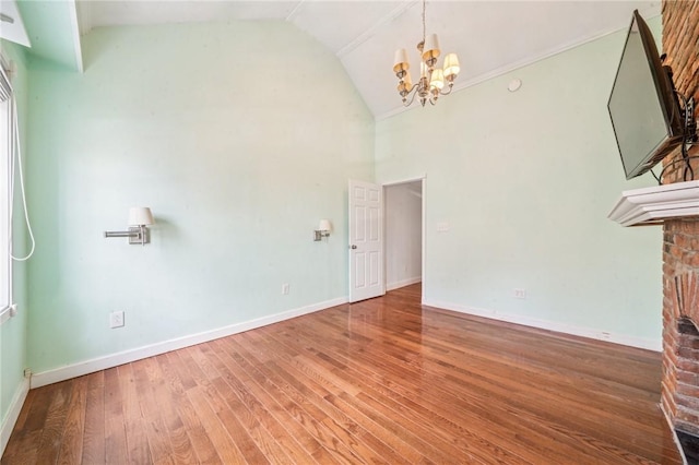 324 Orwell Way, Bloomfield, PA 15224 - empty room with a chandelier, wood finished floors, high vaulted ceiling, baseboards, and a fireplace