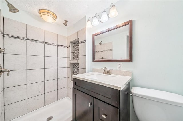 324 Orwell Way, Bloomfield, PA 15224 - bathroom with toilet, vanity, a tile shower, and a textured ceiling
