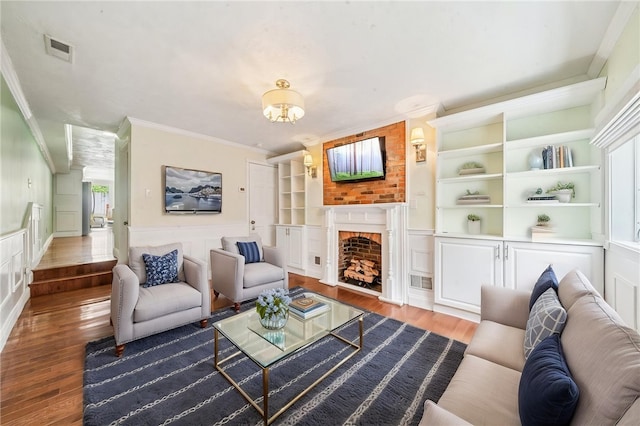 324 Orwell Way, Bloomfield, PA 15224 - living room featuring ornamental molding, wood finished floors, a fireplace, wainscoting, and a decorative wall