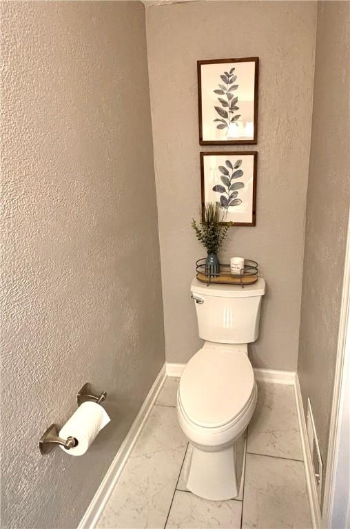 112 Bandywine, Penn Twp Wml, PA 15642 - bathroom featuring marble look tile flooring, toilet, and baseboards
