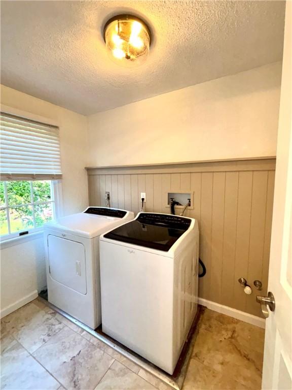 112 Brandywine, Manor, PA 15642 - laundry area featuring washer and dryer, a textured ceiling, and wainscoting