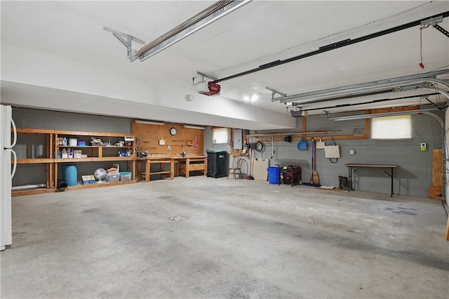 465 Hewitt Ave, Canton Twp, PA 15301 - garage with electric panel, a garage door opener, freestanding refrigerator, and a workshop area