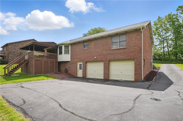 465 Hewitt Ave, Canton Twp, PA 15301 - rear view of property featuring brick siding, asphalt driveway, a garage, and stairs