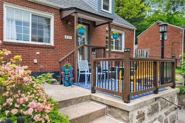 471 Filmore Rd, Forest Hills Boro, PA 15221 - view of exterior entry featuring a shingled roof, brick siding, and a wooden deck