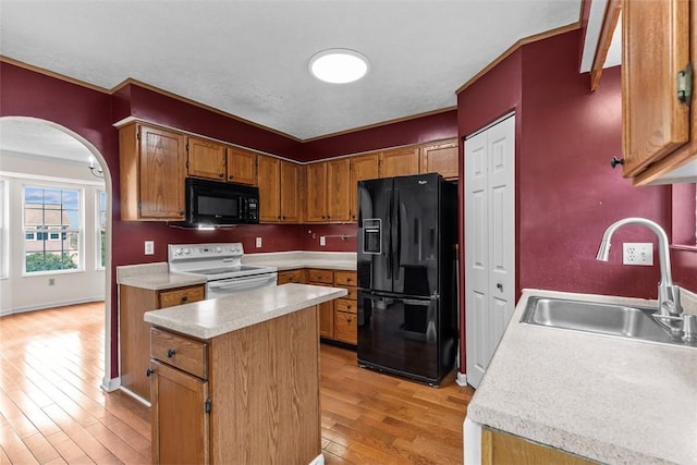 300 Green Flds, Cranberry Twp, PA 16066 - kitchen featuring black appliances, a sink, light wood-style flooring, arched walkways, and brown cabinetry