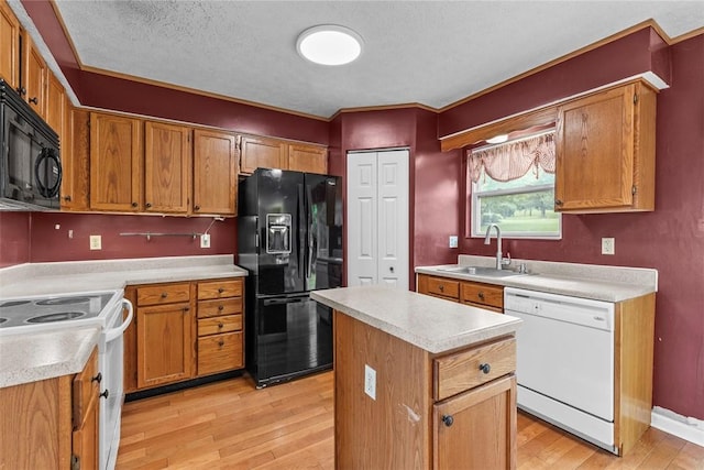 300 Green Flds, Cranberry Twp, PA 16066 - kitchen featuring black appliances, a sink, light wood-type flooring, light countertops, and a textured ceiling