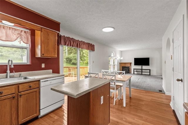 300 Green Flds, Cranberry Twp, PA 16066 - kitchen featuring white dishwasher, a sink, a kitchen island, a fireplace, and light wood-style floors