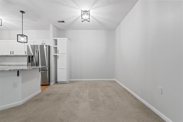 200 Hidden Ridge Ct Unit 202, South Park, PA 15129 - kitchen with stainless steel fridge, light carpet, white cabinets, tasteful backsplash, and hanging light fixtures