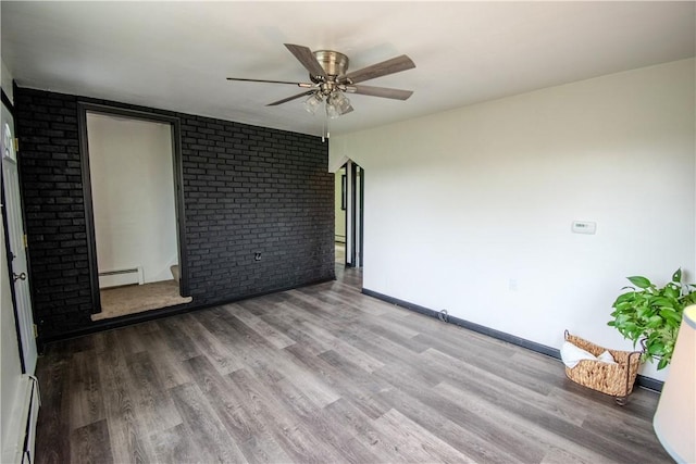 721 Grant Ave, West Mifflin, PA 15122 - spare room featuring a baseboard heating unit, a baseboard radiator, wood finished floors, a ceiling fan, and brick wall