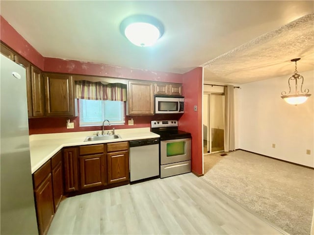 109 Parkside Dr, West Mifflin, PA 15122 - kitchen with stainless steel appliances, a sink, light countertops, and light wood-style flooring
