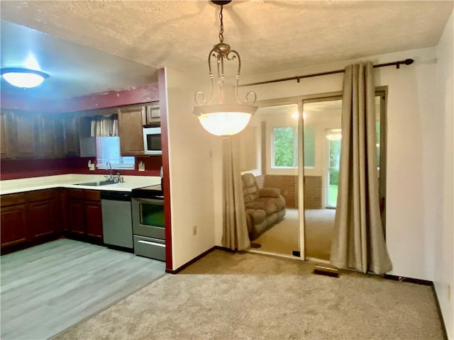109 Parkside Dr, West Mifflin, PA 15122 - kitchen featuring stainless steel appliances, a sink, light countertops, a textured ceiling, and baseboards