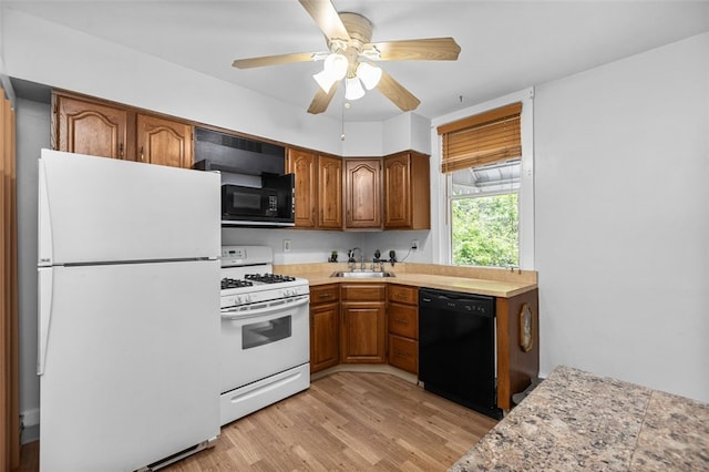 329 Ivondale St, Greenfield, PA 15207 - kitchen with black appliances, a sink, light countertops, brown cabinets, and light wood finished floors