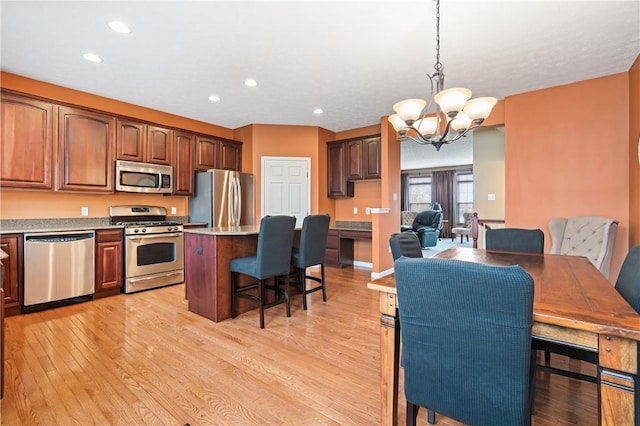 3005 Village Run Rd, Pine Twp Nal, PA 15090 - kitchen featuring appliances with stainless steel finishes, a kitchen bar, a chandelier, light wood-style floors, and a kitchen island