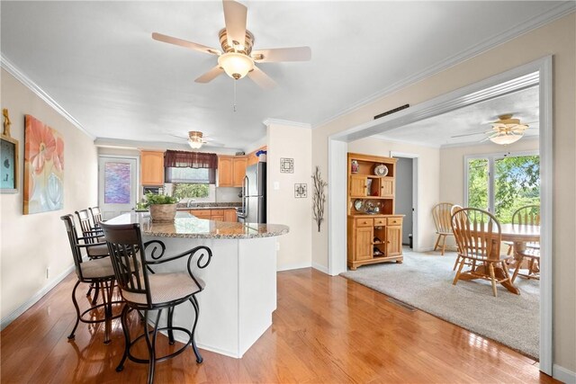 842 Towercrest Dr, Mt Lebanon, PA 15228 - kitchen featuring freestanding refrigerator, a ceiling fan, light wood-style floors, crown molding, and light stone counters