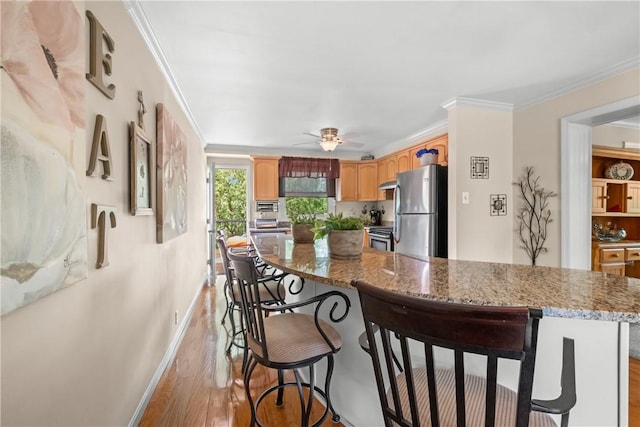 842 Towercrest Dr, Mt Lebanon, PA 15228 - kitchen featuring appliances with stainless steel finishes, light wood-style flooring, a breakfast bar area, a ceiling fan, and baseboards