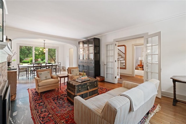 5810 Hampton St, Highland Park, PA 15206 - living area featuring arched walkways, stairs, a fireplace, ornamental molding, and baseboards