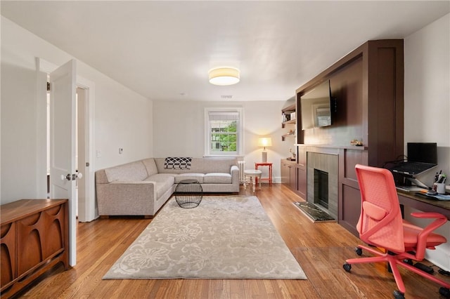 5810 Hampton St, Highland Park, PA 15206 - living area featuring a fireplace with raised hearth and light wood-style floors