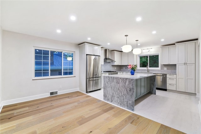 7118 Mcpherson Blvd, Point Breeze, PA 15208 - kitchen with appliances with stainless steel finishes, wall chimney exhaust hood, a sink, tasteful backsplash, and a kitchen island