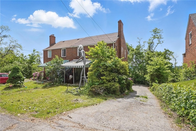 4218 Lebanon Church Rd, West Mifflin, PA 15122 - view of home's exterior featuring a chimney, brick siding, and a yard